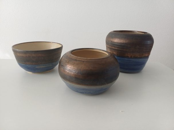 Drie keramische schalen met een bruine en blauwe afwerking.