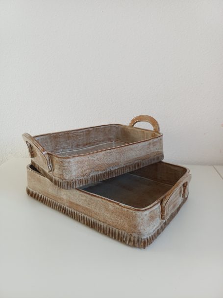 2 handgemaakte keramische  met handvaten ovenschalen op elkaar gezet
