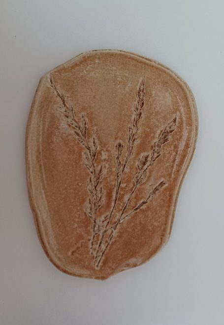 keramisch aardekleurig schaaltje  met afdruk van grassoorten er in.