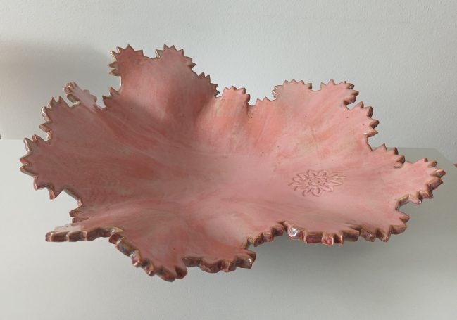 Fruitschaal. Aan de binnenkant roze. Buitenzijde met bloemmotief