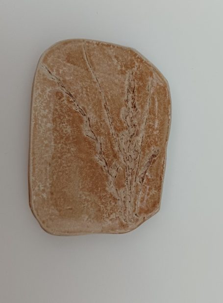 keramisch aardekleurig schaaltje  met afdruk van grassoorten er in.