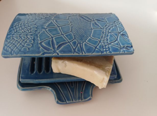 Voorzijde van blauw zeepbakje met afdak waar motief op zit. Speciaal voor natuurzeep in de douche