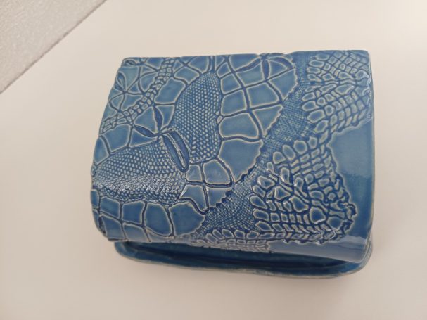 Bovenzijde van blauw zeepbakje met afdak waar motief op zit. Speciaal voor natuurzeep in de douche